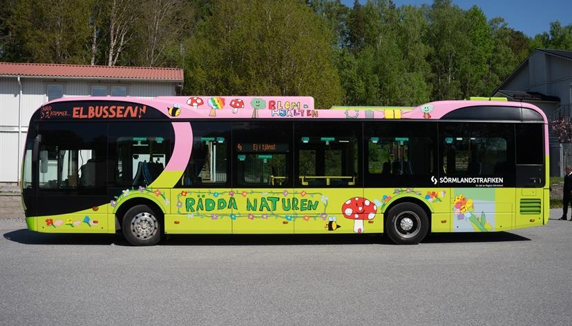 Designad buss i grönt och rosa med ritade bilder på 