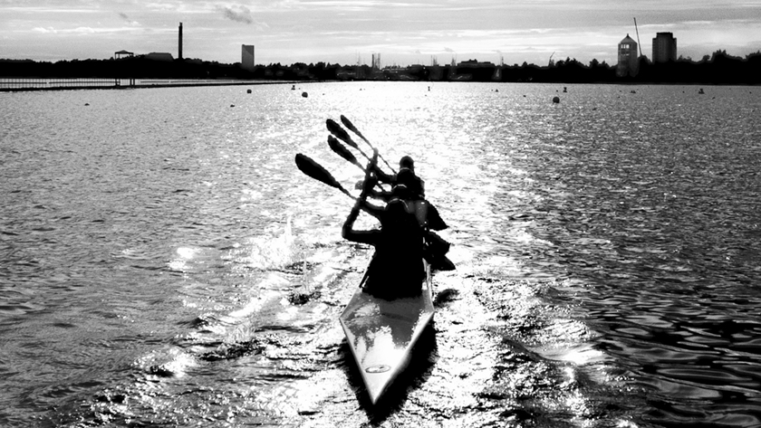 Svartvit bild på paddling i kajak i solsken