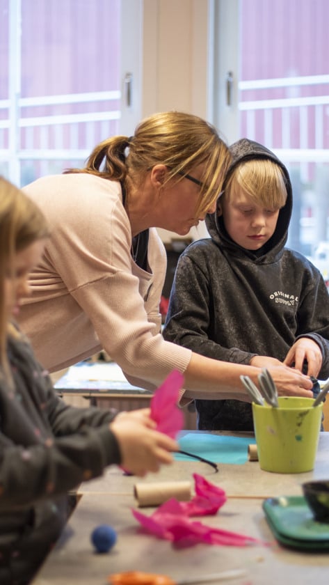 fritidshemslärare pysslar med elever