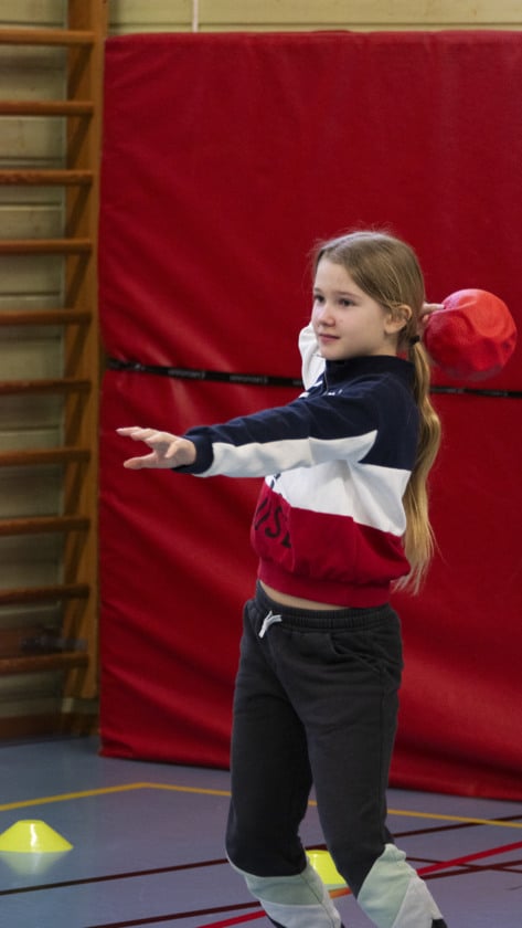 elev kastar boll i gympasal