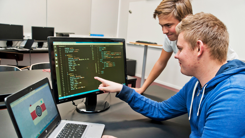 Två elever tittar på en datorskärm