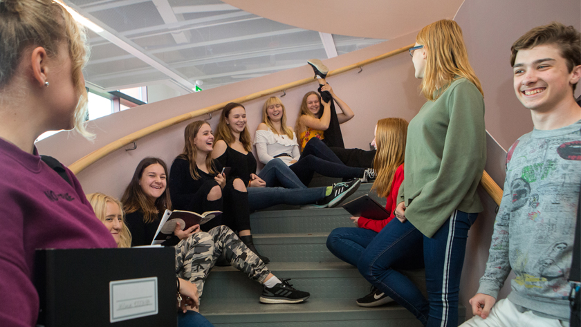 Flera elever sitter i en trappa