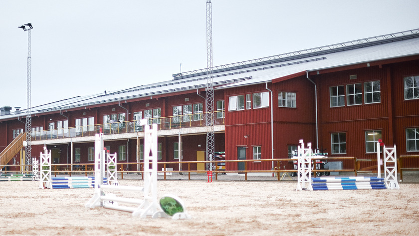 Den röda ridanläggningen med ridbanan och hinder framför