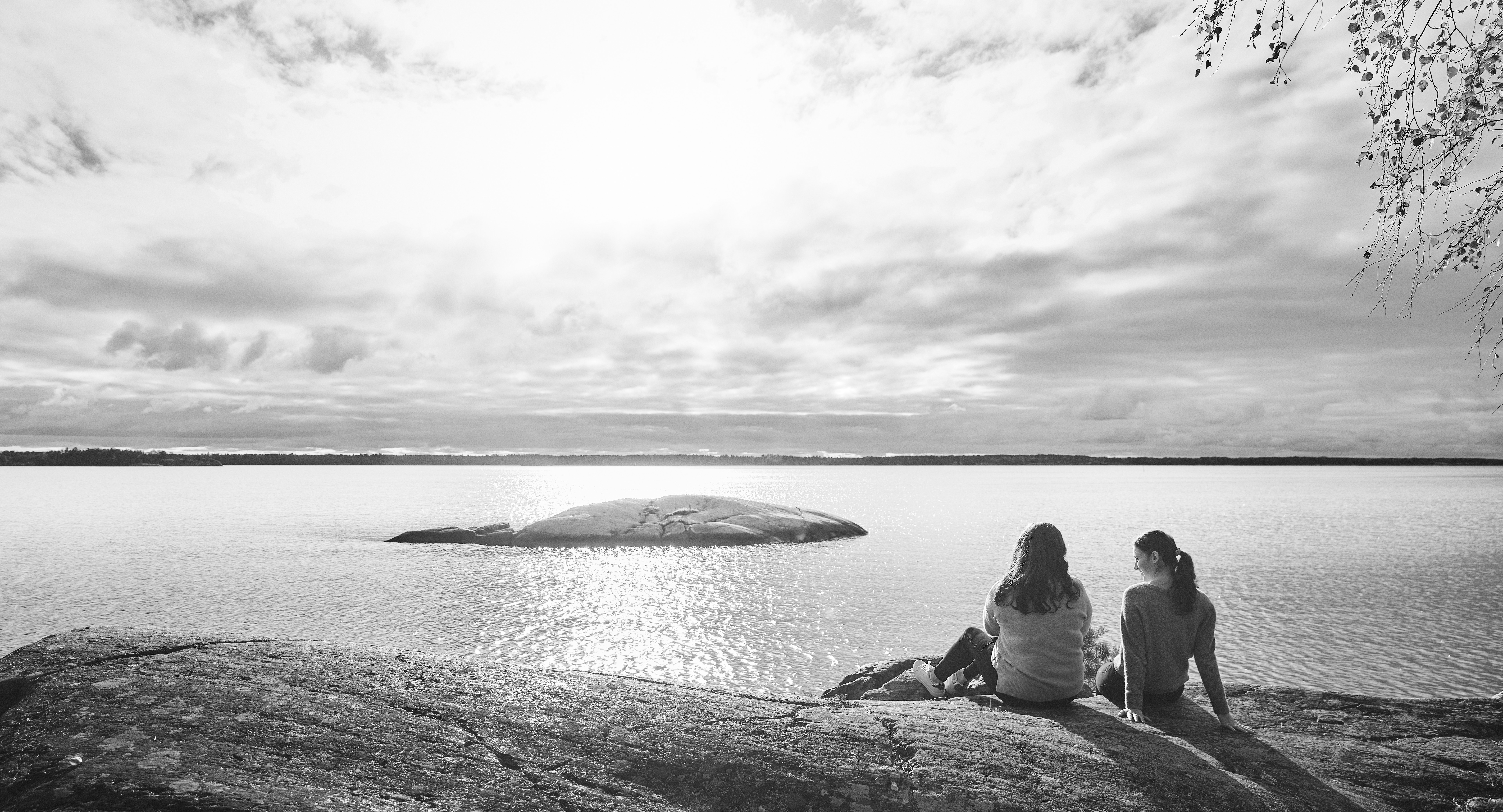 Två tjejer på en klippa vid havet