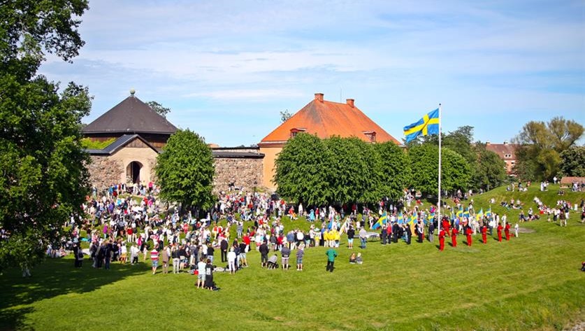 Människor som står på en gräsmatta framför ett slott