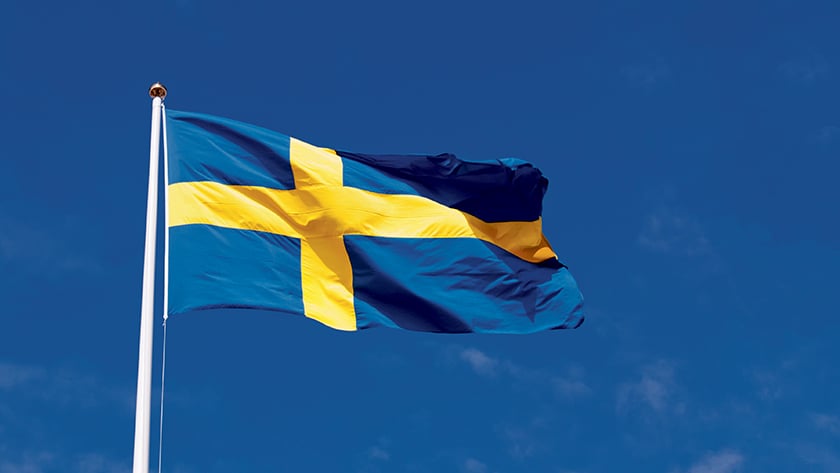 Svensk flagga i gult och blått mot blå himmel