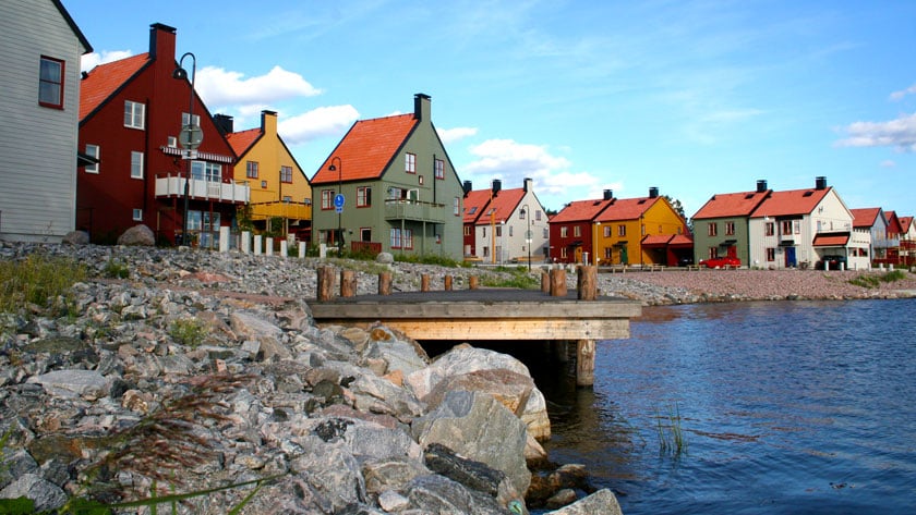 Hus i olika färger på rad längs med vattnet