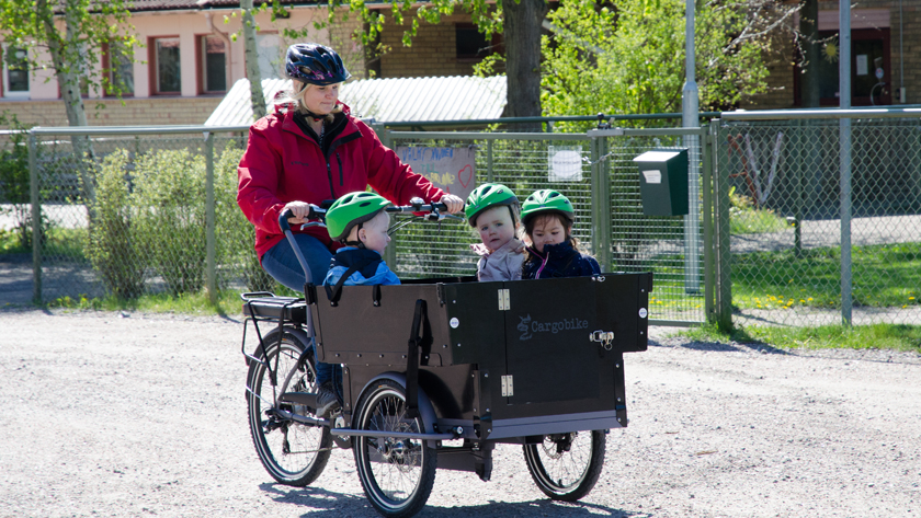 Två bilder i en och samma: Blå förskolebuss och förskolecykel, en cykel med stor låda med barn i Två bilder i en och samma: Blå förskolebuss och förskolecykel, en cykel med stor låda med barn i