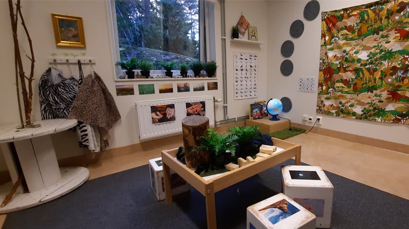 Bild inifrån ett av rummen med stort tyg på väggen med djurmotiv , bilder och annat om djur och natur