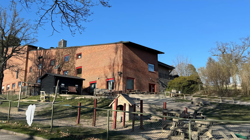 Röd tegelbyggnad för Fransiscus förskola och gården utomhus