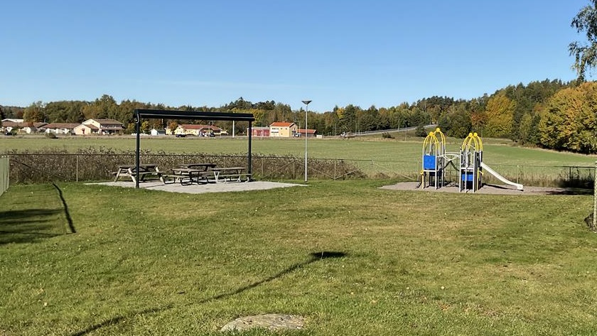 Förskolans uteplats med gräs och klätterställning