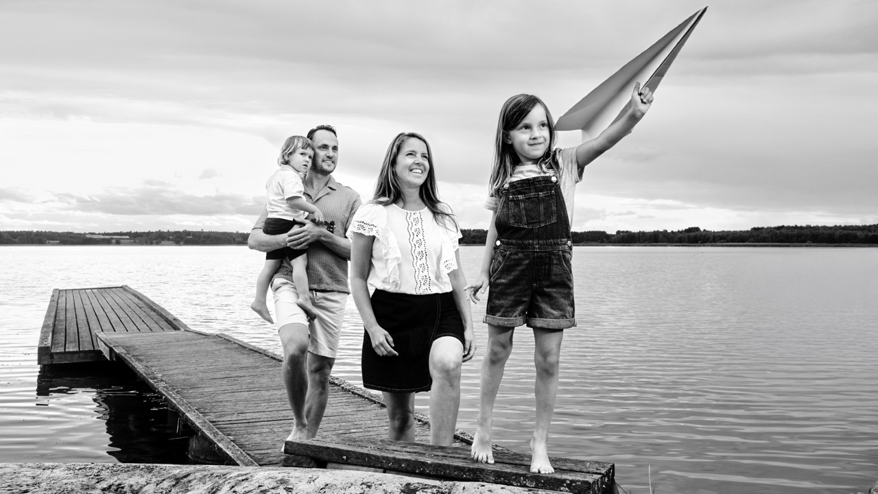 En familj står på en brygga vid vattnet